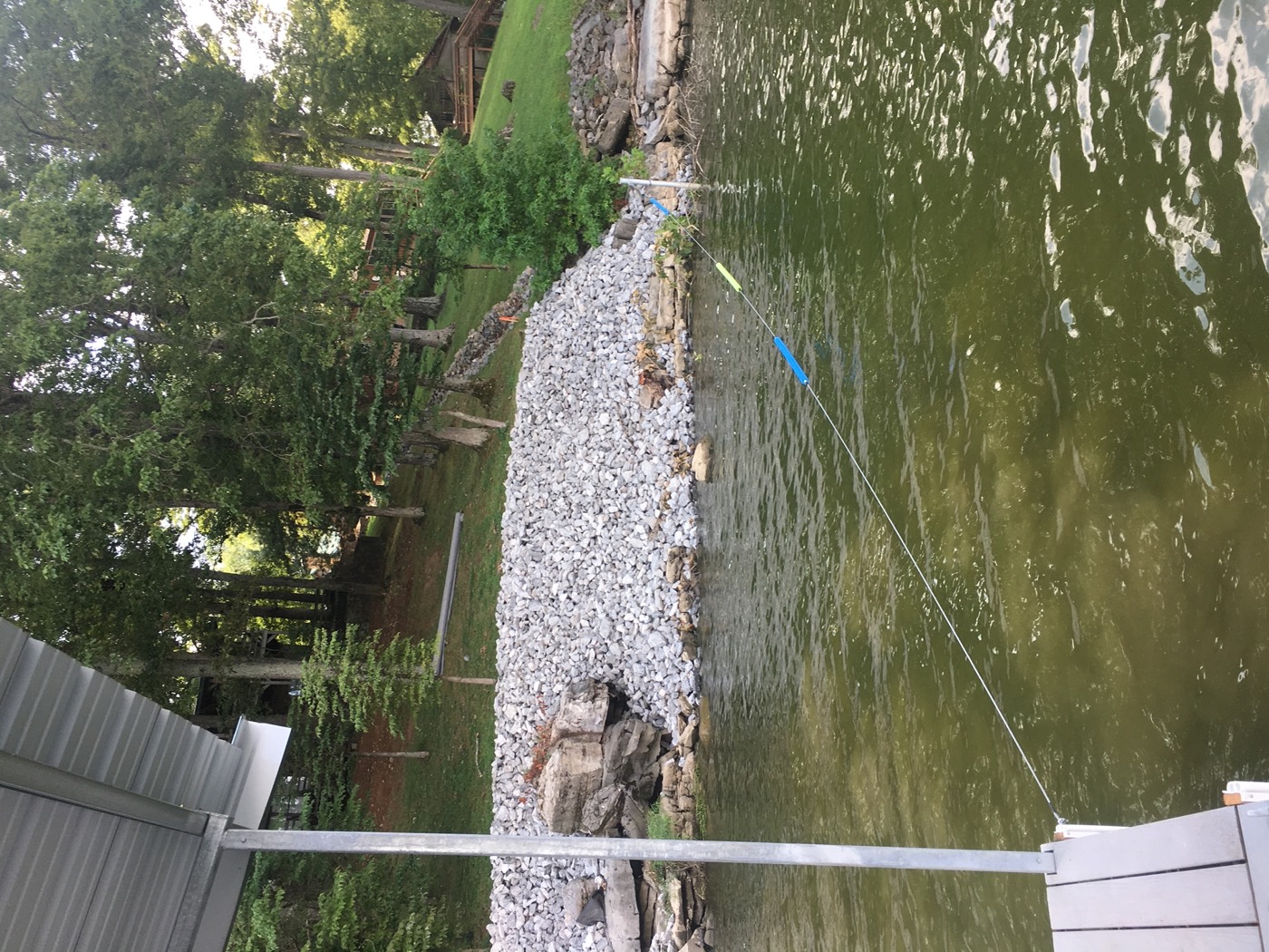 Finished riprap bank of fresh limestone running from the waterline up the slope